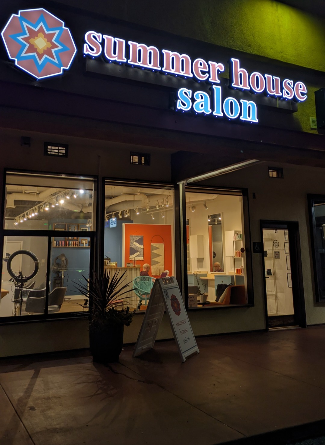 Summer House Salon storefront lit up at night